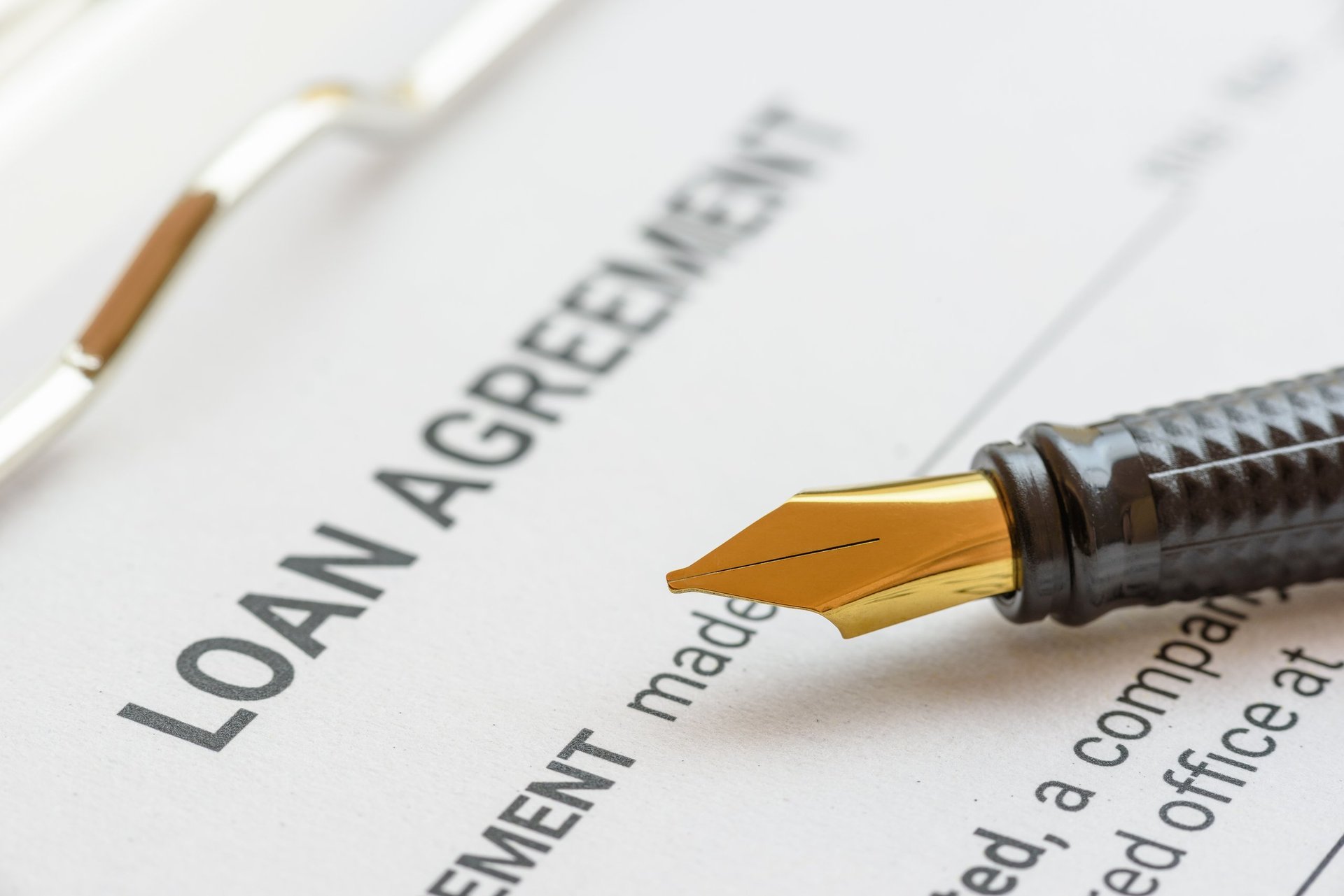 Business loan agreement document with fountain pen signing loan approval