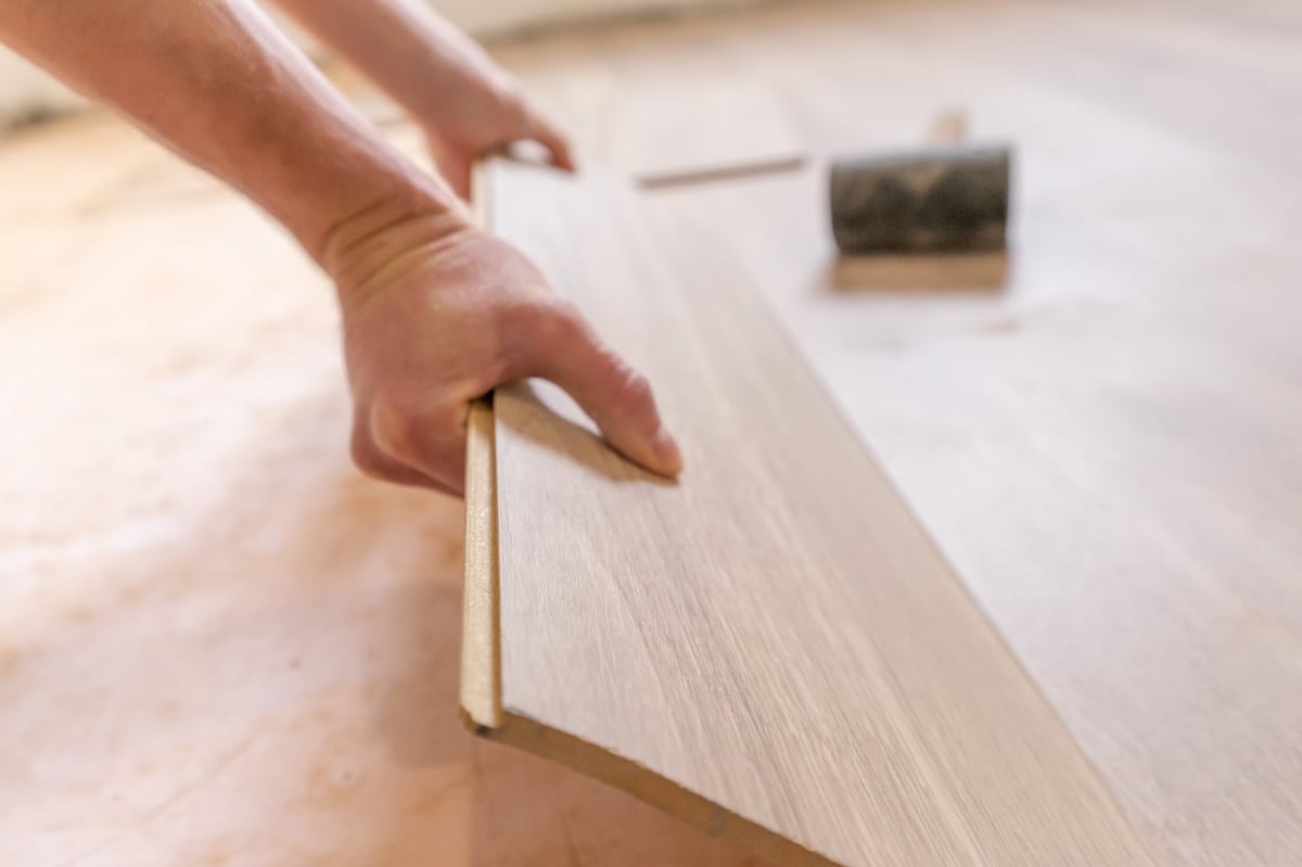 Worker installing laminate flooring during home improvement
