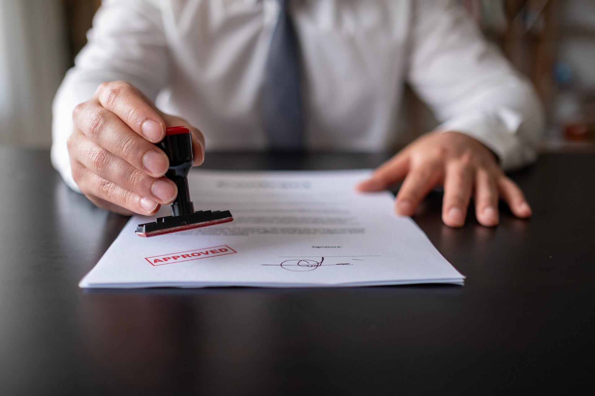 Real estate agent stamping approved on document for sale approval