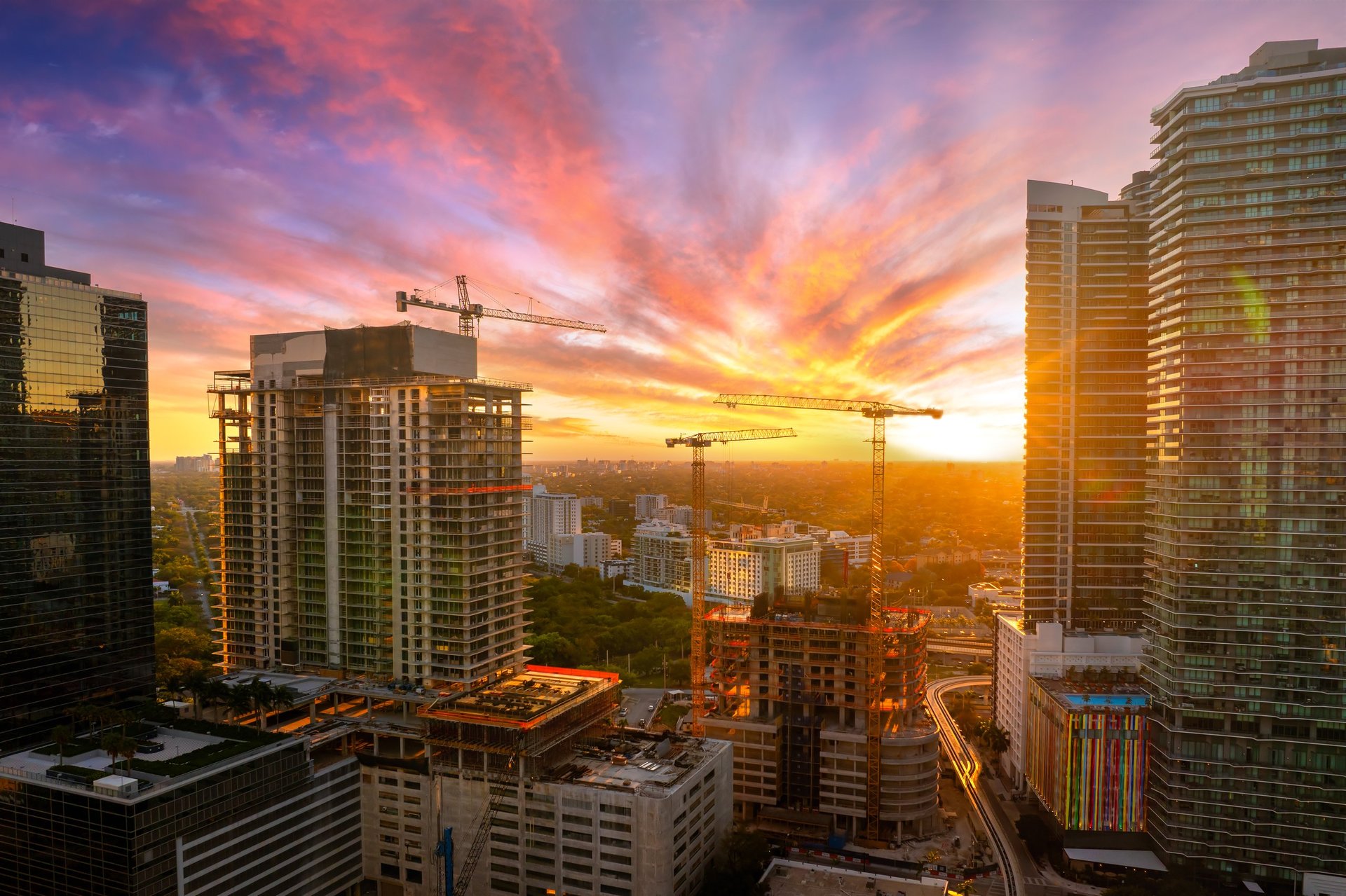 Developing American megapolis with new high-rise buildings under construction at sunset