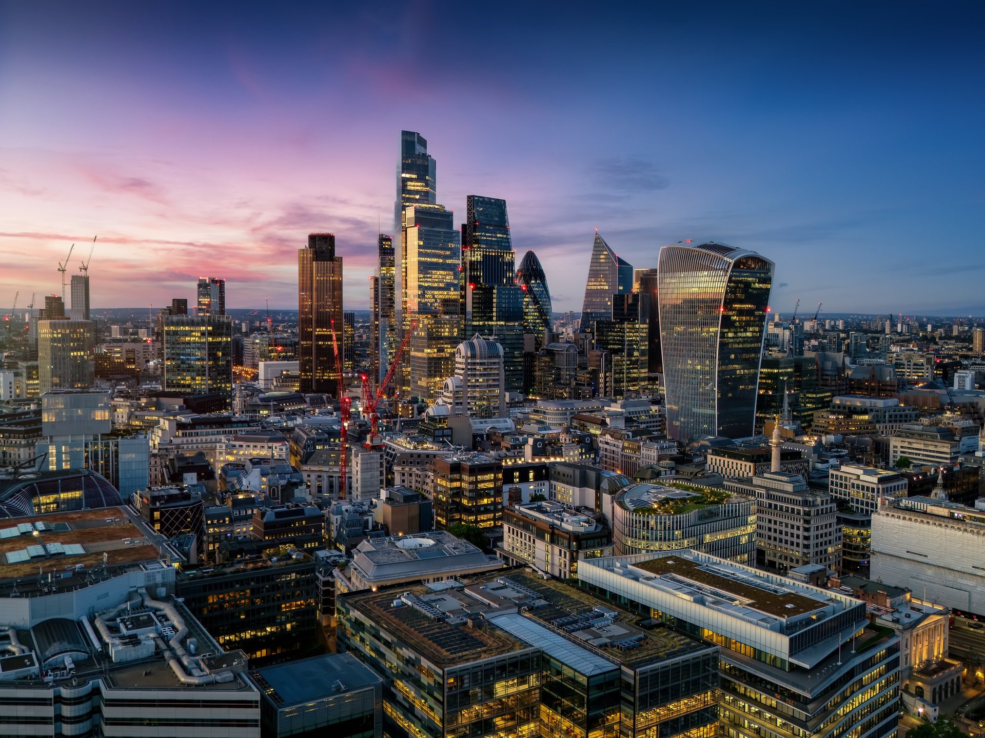 Aerial view of the illuminated skyscrapers at the City of London during evening time