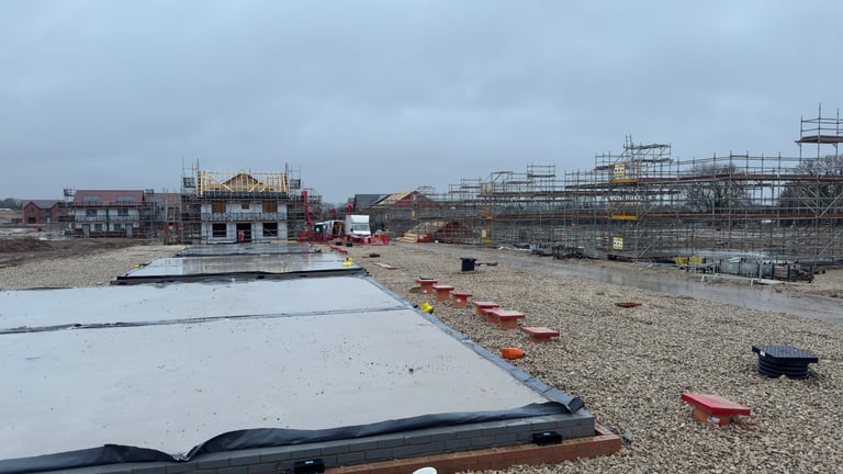 A construction site with buildings under construction, scaffolding, and various materials