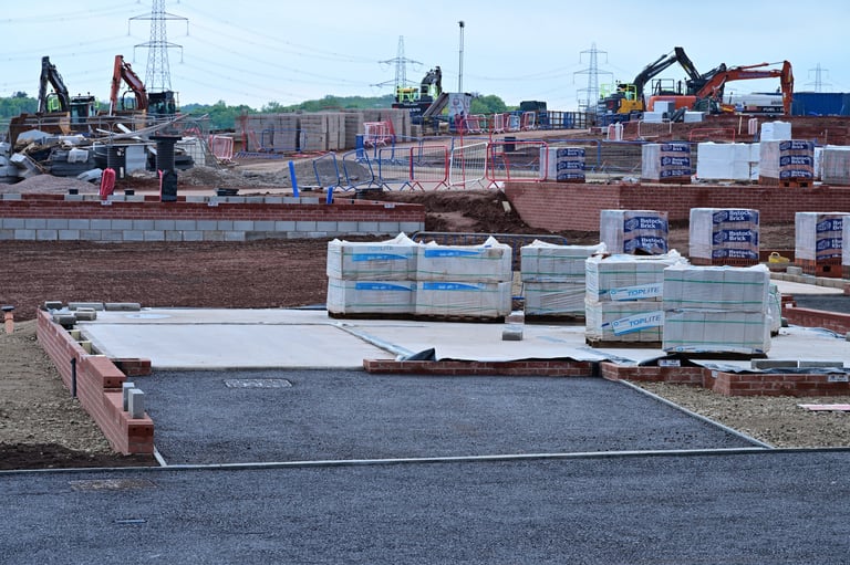 Early stage construction site with foundations, materials and excavators